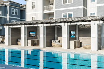 Sundeck with lounge chairs, tables, and chairs and four private cabanas each outfitted with daybed, minibar refrigerator and television